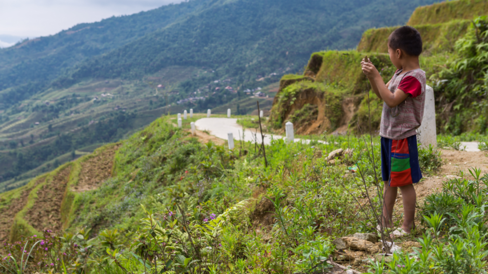 boy overlooking the side of a mountain